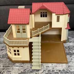 a doll house with stairs and red roof