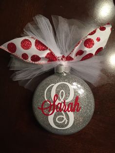 a christmas ornament with a polka dot bow and the word g on it