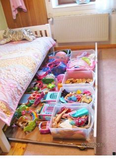 a drawer full of toys in a child's bedroom next to a bed and window