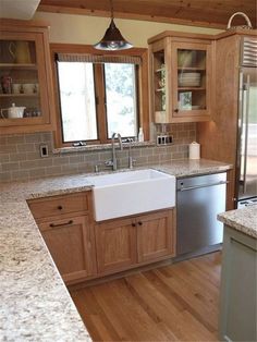 a kitchen with wooden cabinets and granite counter tops, stainless steel refrigerator and dishwasher