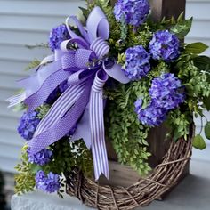 a basket filled with purple flowers and greenery