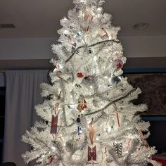 a white christmas tree decorated with ornaments and lights