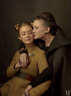 two women in star wars costumes are touching each other's forehead while they both have their eyes closed