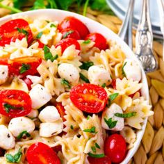 a pasta salad with tomatoes, mozzarella and parsley