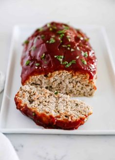 meatloaf with ketchup on a white plate