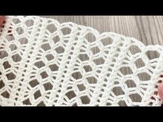 the white crocheted fabric is on top of a wooden table