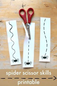 spider scissors are sitting on top of the paper cut out to look like it is cutting