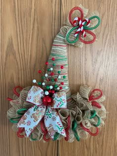 two christmas wreaths made out of burlocks and ribbons on a wooden surface