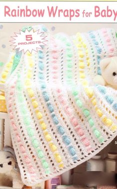 there is a crocheted baby blanket on top of a crib next to stuffed animals