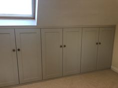 an empty room with several cupboards and a window