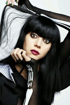 a woman with long black hair is posing for the camera