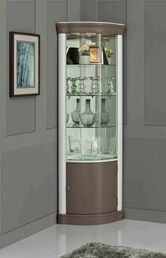 a corner display cabinet with glass doors and shelves on the side, in front of a gray wall