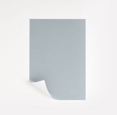 the corner of a piece of paper on a white wall with a light blue background