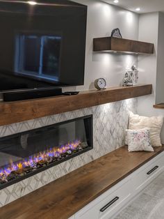 a fireplace in a living room with a flat screen tv on the wall above it