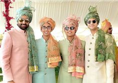 three men in turbans standing next to each other with one man wearing sunglasses