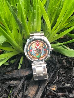 a watch sitting on the ground in front of some grass