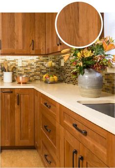 a kitchen with wooden cabinets and white counter tops, has a round mirror above the sink