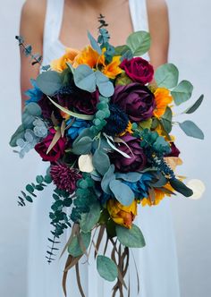 a woman holding a bouquet of flowers in her hands