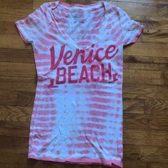 V-Neck Venice Beach American Eagle Shirt. Pink And White Design. Never Worn. V-neck T-shirt For Summer Vacation, Summer Cotton T-shirt With V-neck, Summer Vacation V-neck T-shirt, Summer Cotton V-neck T-shirt, Summer V-neck T-shirt For Vacation, V-neck Cotton T-shirt For The Beach, Summer V-neck Tops For Beach Season, Trendy V-neck T-shirt For Vacation, Casual V-neck T-shirt For Vacation