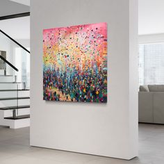 an abstract painting hangs on the wall next to stairs