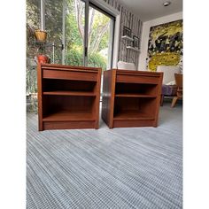 two wooden bookshelves sitting on top of a carpeted floor