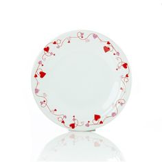 a white plate with hearts painted on the side and red trimmings around it