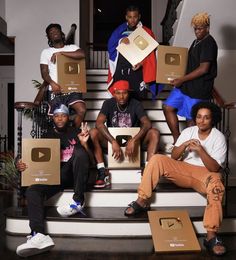 a group of young men sitting on top of stairs with boxes in front of them