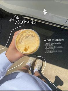 someone is holding up a cup of coffee in front of their car with instructions on how to order