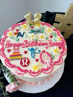 a birthday cake is decorated with flowers and letters