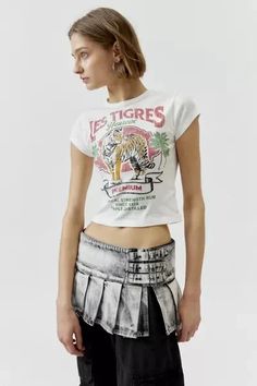 Baby tee with a Les Tigres printed at the front. Hits at the waist in a cropped silhouette with a crew neckline and cap sleeves. Find it exclusively at Urban Outfitters. Features: - Les Tigres graphic baby tee - Tee with a Les Tigres graphic at the front - Cropped silhouette - Crew neckline - UO exclusive Content + Care: - 100% Cotton - Machine wash - Imported Size + Fit: - Model in White is 5’10' and wearing size Small - Measurements taken from size Small - Chest: 24' - Length: 17' Urban Outfitters Letter Print T-shirt For Summer, Fitted Cropped T-shirt With Letter Print For Summer, Spring Short Sleeve Crop Top With Logo Print, Fitted Cotton Cropped T-shirt With Graphic Print, Spring Logo Print Crop Top, Spring Graphic Tee Cropped T-shirt With Logo Print, Cotton Fashion Print Tops For Streetwear, Fashion Print Cotton Tops For Streetwear, Vintage Cropped T-shirt With Graphic Print For Summer