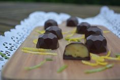 several pieces of chocolate sitting on top of a wooden cutting board with yellow peels