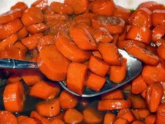 spoons full of cooked carrots sitting on top of each other