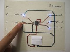 a hand pointing at a circuit diagram on a piece of paper