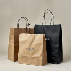 three brown and black shopping bags sitting side by side on a white surface with the words 4 reis printed on it