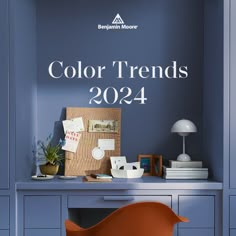 an orange chair sitting in front of a blue desk with the words color trends 2024 on it