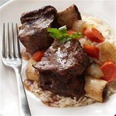 a white plate topped with meat and rice