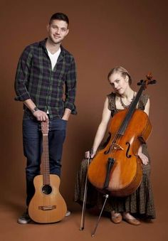 two people standing next to each other with instruments in their hands and one person holding an instrument