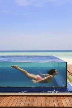 a woman swimming in an empty pool on the beach