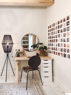 a desk with a mirror, chair and pictures on the wall