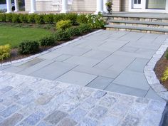 an outdoor patio with steps leading to the front door and landscaping area in front of it