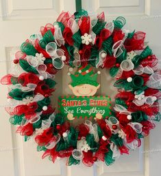 a christmas wreath hanging on the front door with santa's elves saying merry everything