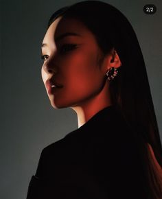 a woman with long dark hair wearing earrings