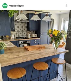 an image of a kitchen setting with blue cabinets and wood counter tops in the center