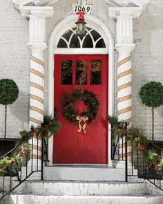 a red door with wreaths and decorations on it