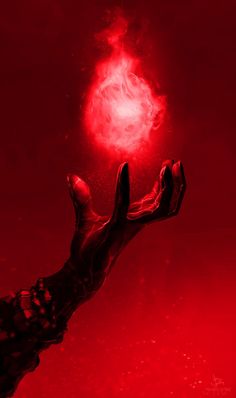 a hand holding a red object in the air with it's light shining brightly