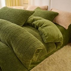 a green comforter and pillows on a bed