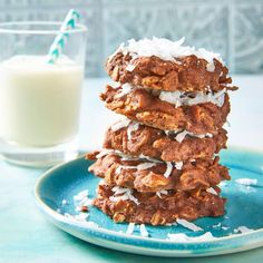 a stack of cookies sitting on top of a blue plate next to a glass of milk