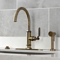 the faucet on the kitchen sink is brass and has no handles or knobs