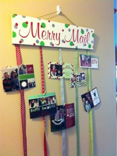 a merry mail sign hanging on a wall with many pictures and ribbons attached to it