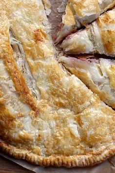 a close up of a pie on a piece of wax paper with some slices cut out